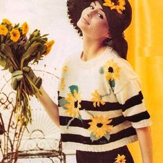 a woman with flowers in her hair is holding a bunch of sunflowers and looking up at the sky