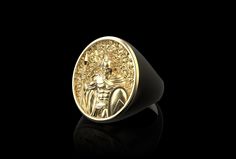 a gold ring with an image of a man in the center on a black background