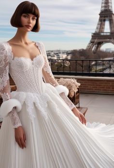 a woman in a white wedding dress standing next to the eiffel tower