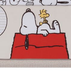 a snoopy dog is sitting on top of a bed