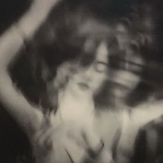 a black and white photo of a woman with her hands behind her back, dancing