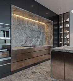 an elegant kitchen with marble counter tops and stainless steel appliances in the back wall is illuminated by recessed lighting