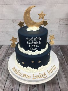 a three tiered cake decorated with stars and moon for a baby's first birthday