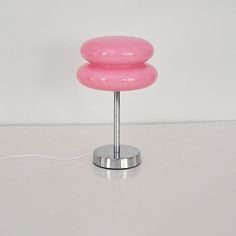 a pink lamp sitting on top of a white table