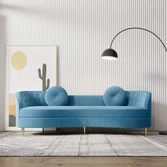 a blue couch sitting on top of a wooden floor next to a wall mounted lamp