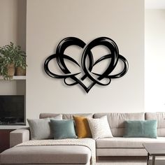 a living room filled with furniture and a large metal heart wall art piece on the wall