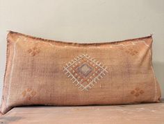 a decorative pillow sitting on top of a wooden table