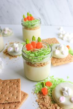 three small jars filled with food on top of a white table next to crackers