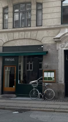 there is a bike parked on the side of the street in front of a building