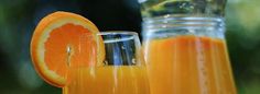 an orange slice next to a glass of juice