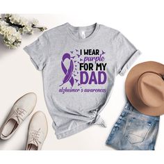 I Wear Purple For My Dad Shirt, Alzheimer's Awareness Shirt, Alzheimer's Support Shirt, Alzheimer's Purple Ribbon T-Shirt, Dementia Shirt We wish everyone to smile with our cute, stylish, and trendy graphic T-shirts. We assure you this shirt is the perfect gift whether you buy it for yourself or someone else. Black text is only used for White, Athletic Heather, Baby Blue, Natural, Orange, Yellow, Heather Peach, Pink, Mint, Cancun, Banana Cream, and Desert Pink colored shirts. White text is used for other colored shirts.  Please review all the photos for the appearance of the designs on the shirts. Color and size charts are included in the listing photos. If you have any other design wish that you couldn't find in the shop, do not hesitate to CONTACT us. We are delighted to help you! MG Des Purple Casual Top For Awareness Events, Casual Purple Top For Awareness Events, Casual Cotton Shirt For Awareness Events, Purple T-shirt For Awareness Events With Letter Print, Purple T-shirt With Letter Print For Awareness Events, Cotton Tops With Letter Print For Awareness Events, Walk To End Alzheimer's, Alzheimer's Awareness, Desert Pink