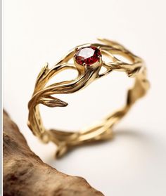 a gold ring with a red stone in it