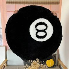 a person holding up a giant black and white object with the letter s on it