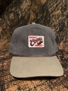 Coors Rodeo patch on a Gray vintage rope brim snapback hat. Vintage Adjustable Canvas Baseball Cap, Retro Snapback Baseball Cap With Logo Patch, Adjustable Canvas Hat With Logo Patch, Casual Canvas Hat With Flat Bill, Vintage Adjustable Trucker Hat Snapback, Vintage Canvas Baseball Cap With Curved Brim, Vintage Adjustable Snapback Hat With Curved Brim, Vintage Adjustable Snapback Trucker Hat, Vintage Canvas Hat For Outdoor