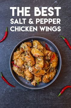 the best salt and pepper chicken wings in a bowl with red chili peppers around it