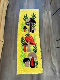 a yellow rug with mushrooms on it in the middle of a wood flooring area