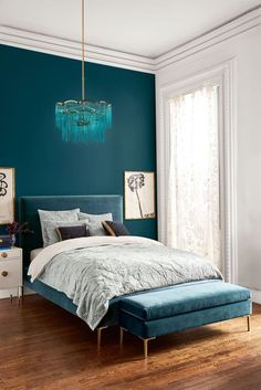 a bedroom with teal walls and wooden floors