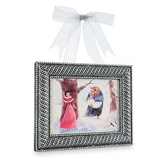 an ornament hanging from the side of a frame with a painting on it