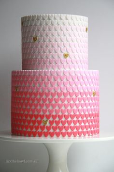 a pink and white cake with hearts on it