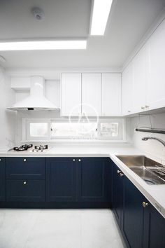 an empty kitchen with blue cabinets and white counter tops is seen in this image from the front view