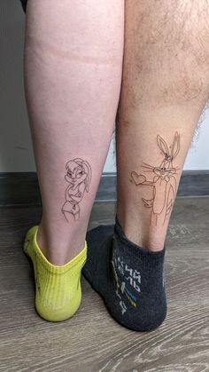 the legs of two people with tattoos on them, one is wearing socks and the other has a yellow sock