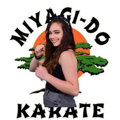 a girl with long hair standing in front of a sign that says myagido karate