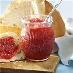 a jar of tomato sauce next to bread on a cutting board