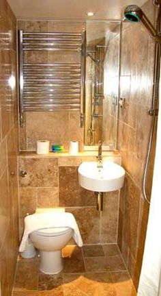 a bathroom with a toilet, sink and shower stall in it's tiled walls