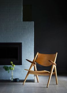 a wooden chair sitting in front of a fireplace