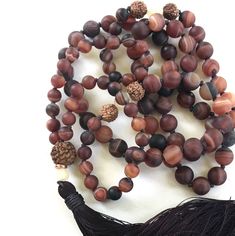 "Mala For Acceptance -Matte Dream Agate Beads Accented With Yellow Jade & Rudraksha - 108 Mala Bead Necklace - Hand Knotted - 8mm & 6mm Beads Length 36.5\" Gently release the body and the mind with this earthy Dream Agate Mala necklace from True Nature Jewelry. It features Dream Agate for grounding and centering along with Rudraksha and Jade in a free-spirited display of design. Each bead is expertly hand knotted for durability. The addition of Rudraksha brings clarity and peace of mind Adjustable Agate Hand-strung Mala, Brown Mala With Natural Stones, Adjustable Hand-strung Agate Mala, Brown Beaded Holistic Mala, Brown Mala With Natural Stones And Round Beads, Brown Mala With Natural Round Beads, Holistic Brown Beaded Mala, Adjustable Agate Mala With Round Beads, Bohemian Brown Mala With Natural Stones