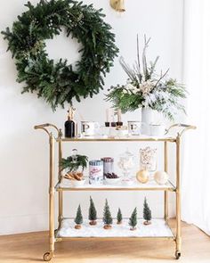 a gold bar cart with christmas decorations and greenery