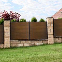 a brick wall and fence with grass in the foreground