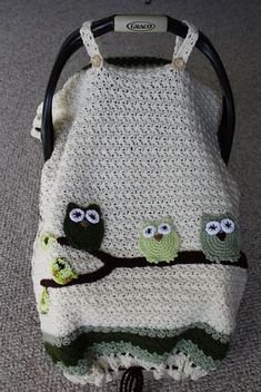 an owl crocheted baby blanket with two owls on it sitting in a stroller