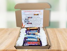 an open box filled with candy on top of a wooden table