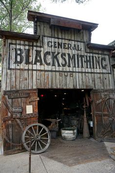 an old wooden building with a sign that says general blacksmithing on it's side