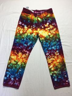 a pair of colorful pants laying on top of a bed