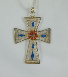 Beautifully detailed gold over sterling silver cross pendant with intricate filigree pattern and red enameled flower and blue enameled diamond patterns. Very classic and elegant. Some patina on it and minimal enamel loss. Marked 925S. I suspect the cross is Scandinavian, but no other marks. Please make your decision of buying accordingly. Measurements: approx. 2.6 inches tall (bale included) and a little bit under 1.7 inches across Please note that due to lighting effects, monitor's brightness, Antique Cross Jewelry With Large Pendant, Ornate Cross Pendant Jewelry For Formal Occasions, Traditional Blue Filigree Jewelry, Antique Cross Pendant Jewelry With Intricate Design, Ornate Hallmarked Cross Jewelry, Gold Filigree Jewelry With Enamel, Traditional Cross Pendant Large Jewelry, Traditional Filigree Cross Jewelry, Formal Filigree Cross Jewelry