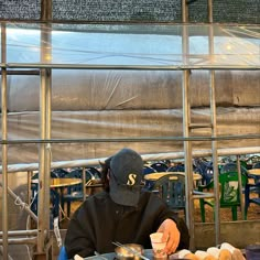 a person wearing a mask sitting at a table with food in front of him,