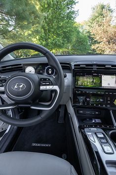 the inside of a car with dashboard, steering wheel and other electronic devices on display