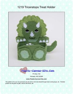 a crocheted green toy sitting on top of a white table next to a blue background