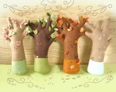 four handmade trees with leaves and flowers on them