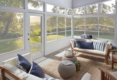 a living room with large windows and lots of furniture on the carpeted flooring