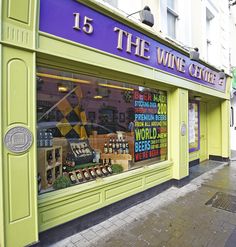 a store front with various items on display in it's glass window displays the names of wine stores