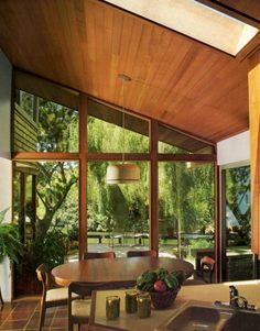 a dining room table and chairs in front of large windows