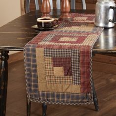 a table with a plaid runner on it and a coffee mug sitting on the side