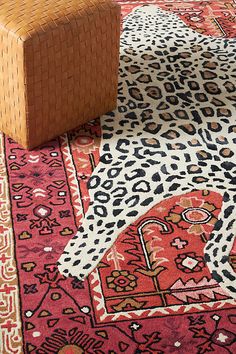 an animal print rug on the floor next to a chair and footstool in front of it