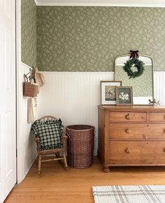 a room with a dresser, chair and mirror on the wall next to a door