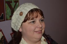 a woman wearing a white knitted hat with buttons on the front and back of her head