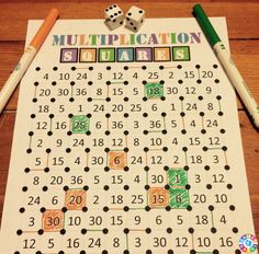 a board game with dices and numbers on it, next to two pencils