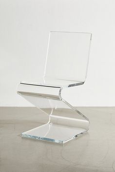 a clear chair sitting on top of a cement floor